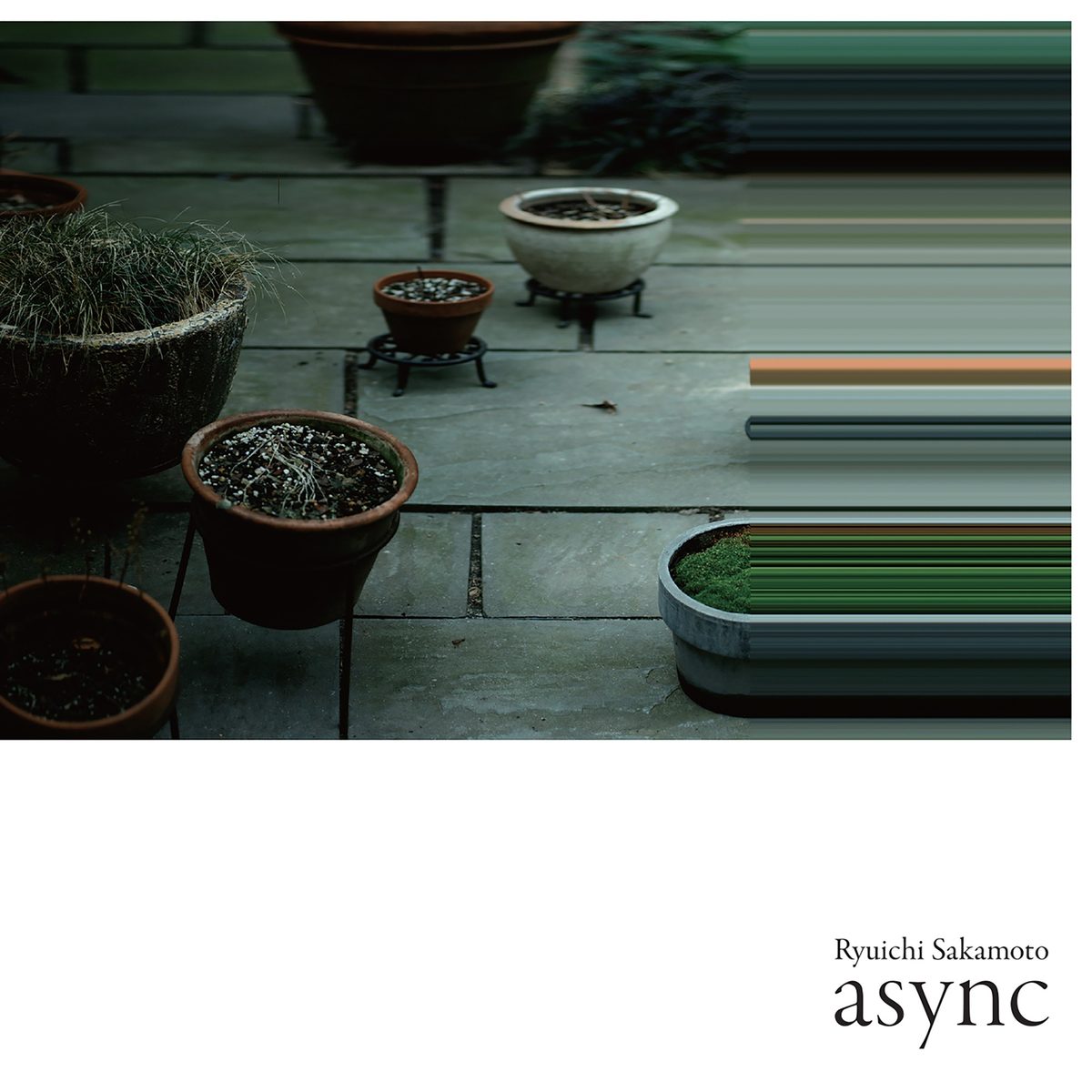 async — album artwork: potted plants on a stone patio, the image glitching into horizontal bands
